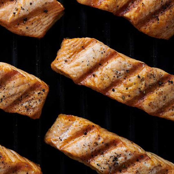 Filetes de salmón a la parrilla con marcas de grillado y especias – cocinados a la perfección con el CHEF'S COMBI de HOBART para resultados uniformes y profesionales.