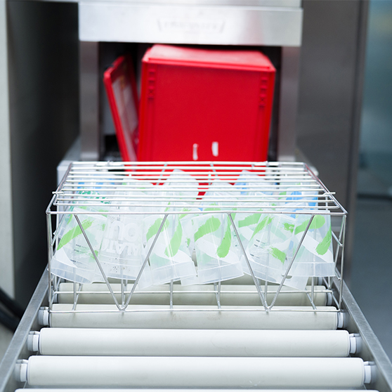 Cesta de acero inoxidable con vasos reutilizables frente al sistema HOBART FUX para limpieza de vasos, solución de alto rendimiento para eventos masivos con bajos costos operativos.