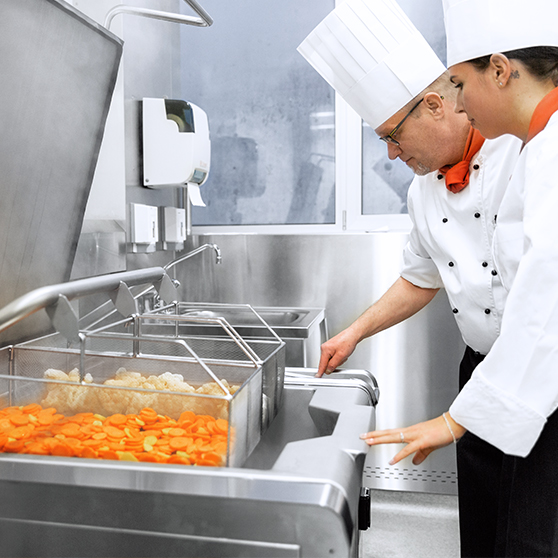 HOBART Precipan funcionando en una cocina profesional moderna, equipo de cocción multifunción de acero inoxidable con gran capacidad, ideal para preparar verduras como zanahorias y coliflor, ahorra tiempo y energía, ofrece control preciso de temperatura y limpieza sencilla para hostelería y restauración.
