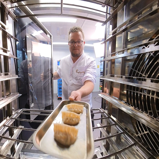 Una bandeja con alimentos preparados se introduce en la cámara de cocción del HOBART CHEF’S COMBI, vista desde el interior para resaltar el flujo de trabajo.